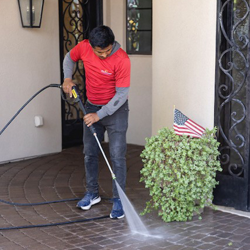 A man is cleaning the floor with a pressure washer in Phoenix, AZ