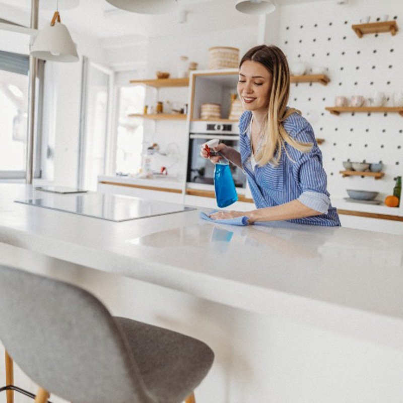 A lady cleaning countertops showcasing dining room cleaning services in Phoenix, AZ.