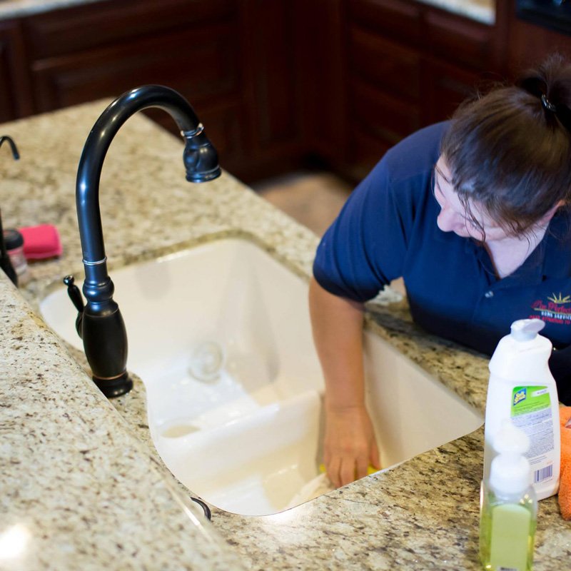 Lady Cleaning a Sink showcasing cleaning services by The Perfectionist Cleaning Services in Phoenix