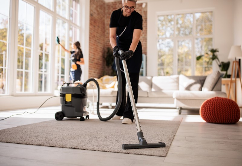 Two women clean a room, showcasing one-time cleaning services available in Phoenix, AZ.