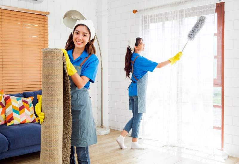 Two women cleaning a room with a rug, representing post remodeling cleaning in Phoenix, AZ