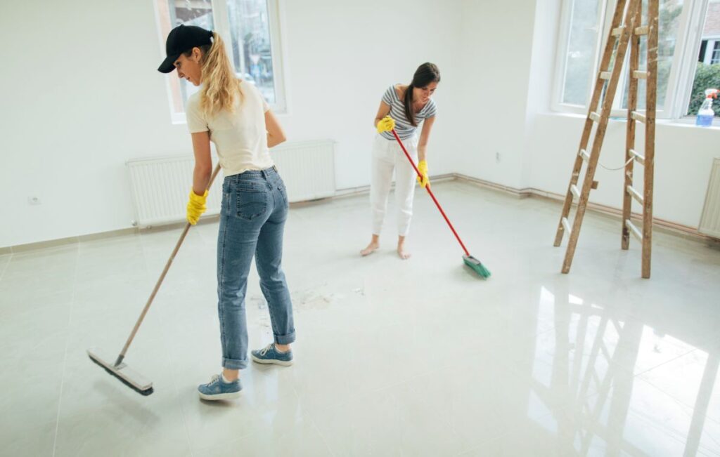 Two Women Cleaning the Floor with a Brush